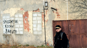 Łukasz z Bałut przy muralu widniejącym na ulicy Brzeskiej. Fot Bogdan Jankowski