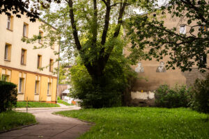 Ulica Spacerowa. Widok na kamienicę w której mieszkał Dawid Sierakowiak (po lewej) oraz mural z cyrku "Dzieci Bałut" przedstawiający Dawida (chłopiec po prawej). Fot. Ada Świerżewska